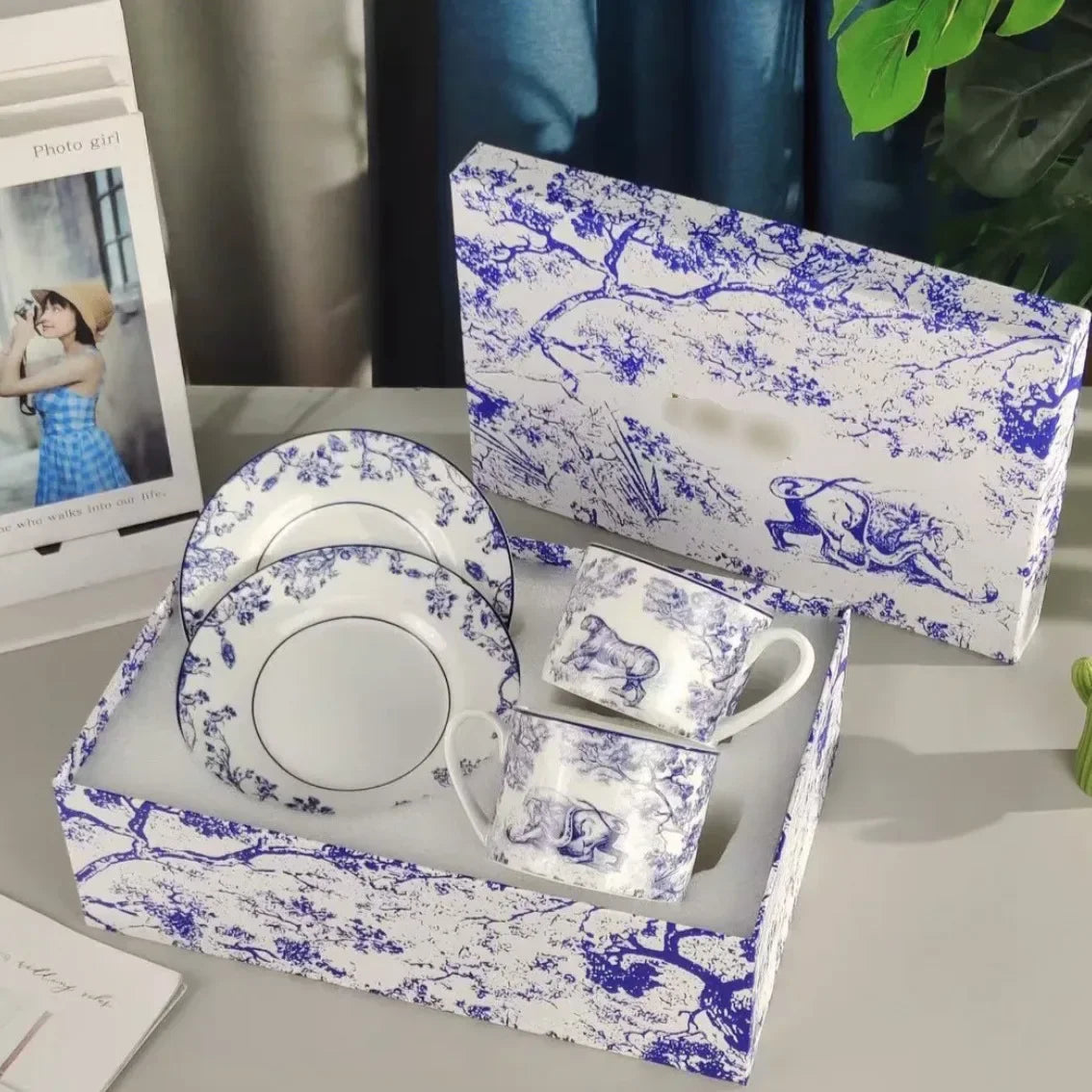 Ceramic coffee set with blue and white pattern in a matching box on a table.