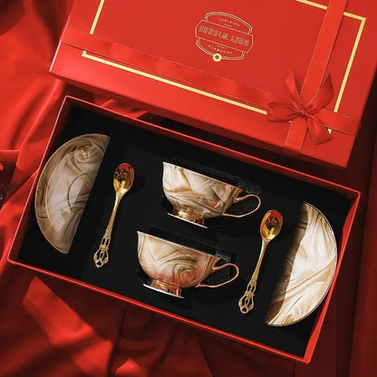 Ceramic coffee set with gold accents in a red gift box.