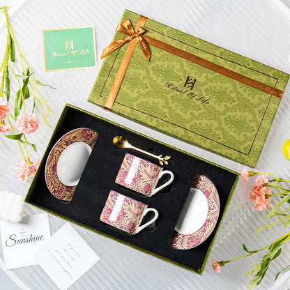 Coffee set with floral design in a decorative box, surrounded by flowers and cards.