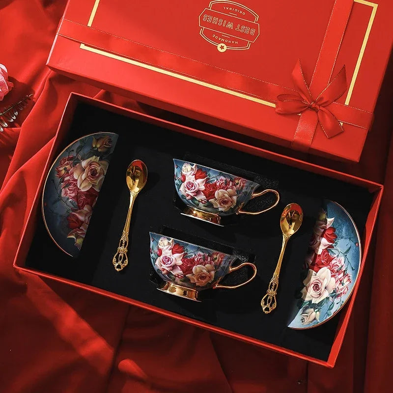 Coffee set with floral designs in a red gift box on a red fabric background