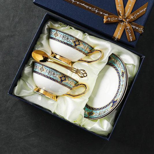Decorative coffee set with gold accents in a gift box on a dark surface